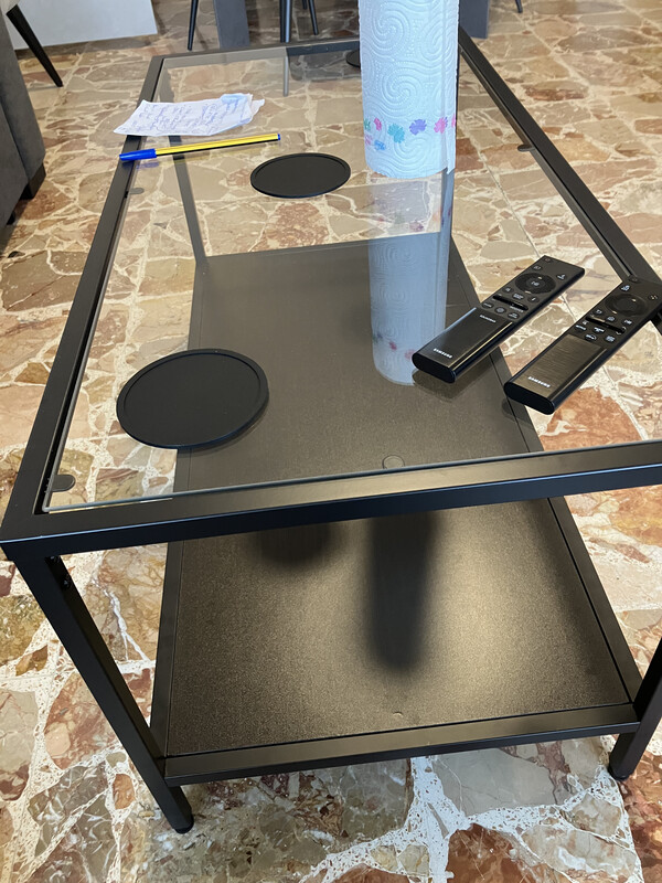 Remote controls and black glass coffee table